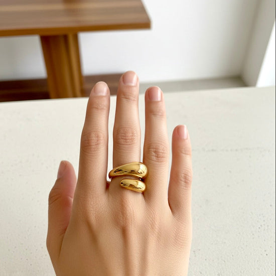 Anillo dorado modelo Abrazo con diseño envolvente en acero inoxidable sobre modelo
