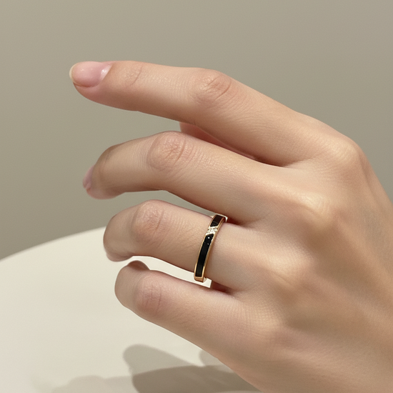 Anillo ajustable dorado con esmalte negro y circonitas sobre modelo