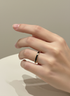 Anillo ajustable dorado con esmalte negro y circonitas sobre modelo