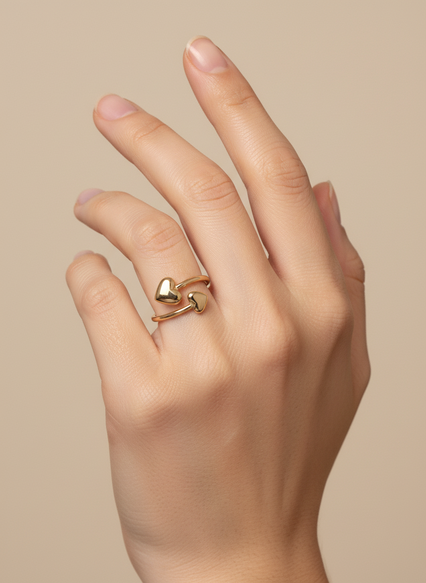 Anillo ajustable abierto con dos corazones en acero y baño de oro 18K sobre modelo