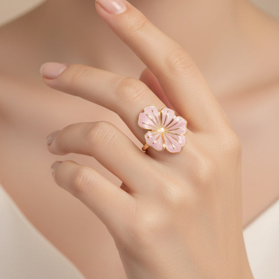 Anillo ajustable con flor esmaltada rosa palo y baño de oro 18K en mano de modelo