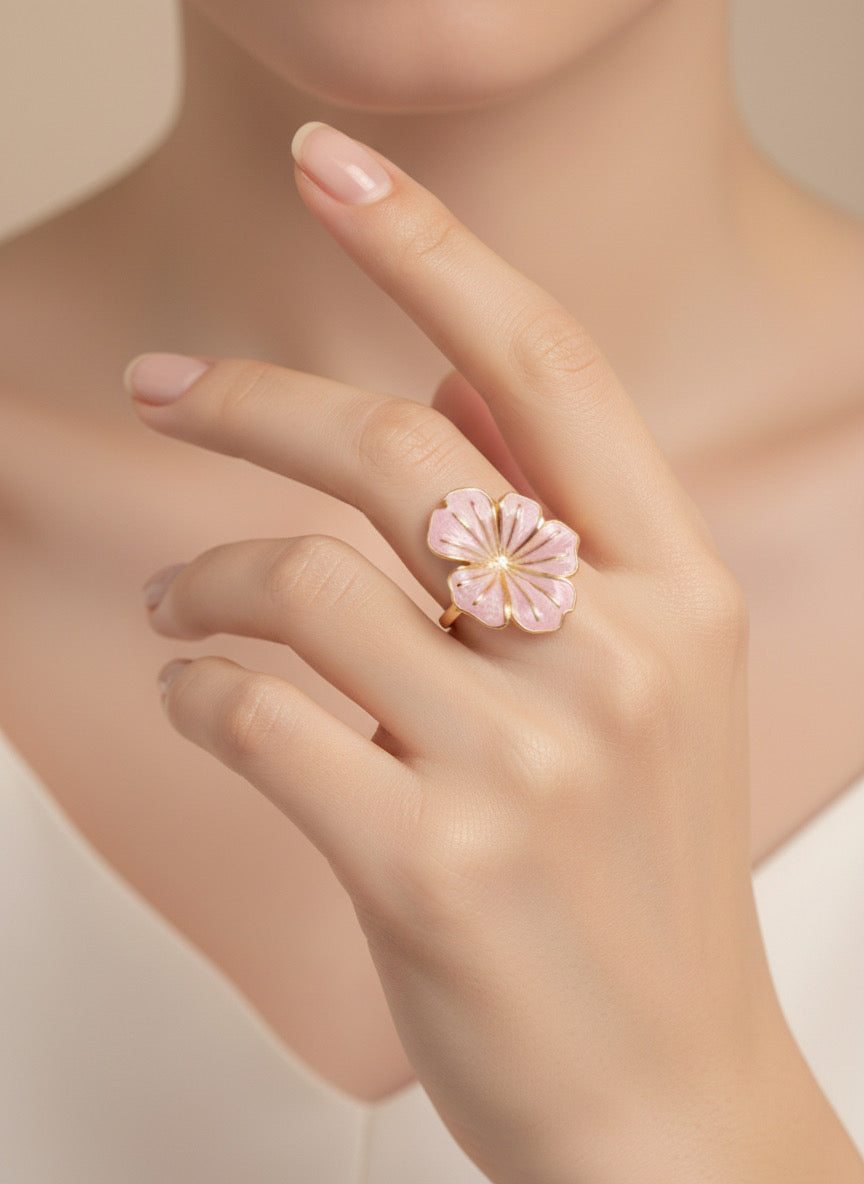 Anillo ajustable con flor esmaltada rosa palo y baño de oro 18K en mano de modelo