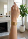 Brazalete ancho abierto efecto hilos dorados en acero con baño de oro 18K sobre modelo
