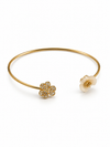 Pulsera Dúo Floral Encantado BRAVATA, detalle 4: pulsera rígida abierta con dos flores en los extremos; una flor con cinco pétalos rojos facetados y centro dora