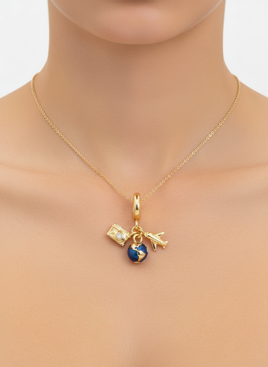 Charm dorado con globo azul, cámara con circonita y avión en acero con baño de oro 18K sobre modelo