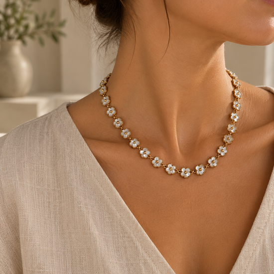 Collar Primavera Rubí BRAVATA, detalle 2: cadena con eslabones pequeños y flores de cinco pétalos en color blanco con centro redondo dorado, unidas entre sí for