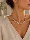 Collar Primavera Rubí BRAVATA, detalle 2: cadena con eslabones pequeños y flores de cinco pétalos en color blanco con centro redondo dorado, unidas entre sí for