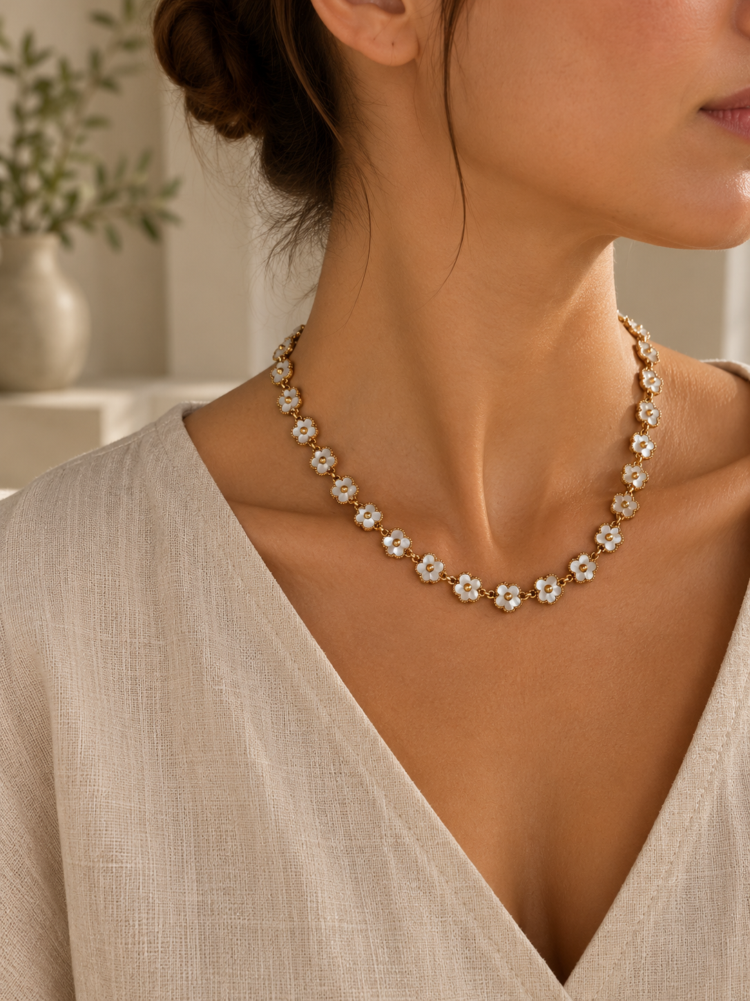 Collar Primavera Rubí BRAVATA, detalle 2: cadena con eslabones pequeños y flores de cinco pétalos en color blanco con centro redondo dorado, unidas entre sí for