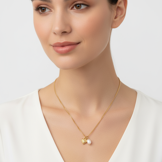 Collar Amor con colgante de corazón grabado y perla natural irregular en acero inoxidable dorado sobre modelo