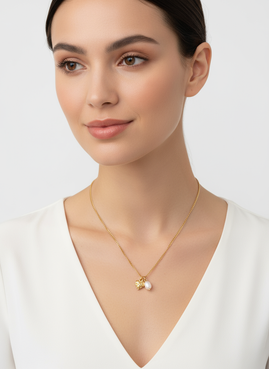 Collar Amor con colgante de corazón grabado y perla natural irregular en acero inoxidable dorado sobre modelo