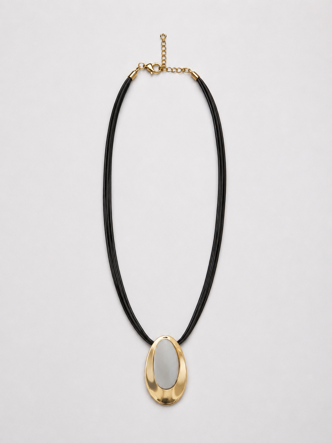 Collar con colgante óvalo dorado y cordón negro múltiple