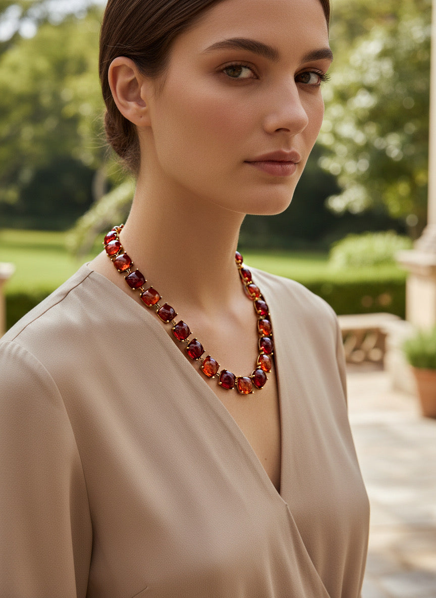Collar corto dorado con cabujones “cushion” en degradado granate-rojo sobre modelo