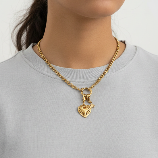 Collar Love dorado en acero inoxidable con colgante de corazón grabado y cierre en aro decorativo sobre modelo