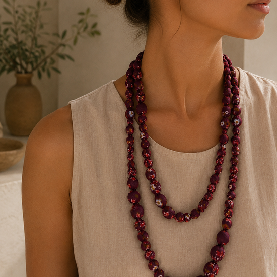 Mujer llevando el Collar Mirea rojo de cuentas de tela con estampado floral.