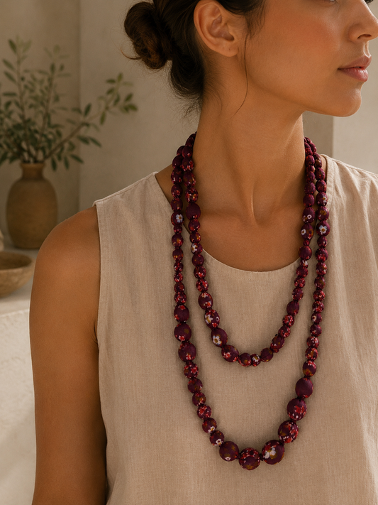 Mujer llevando el Collar Mirea rojo de cuentas de tela con estampado floral.