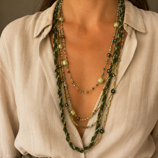 Mujer llevando el Collar Varda verde multicapa con cuentas y detalles dorados.