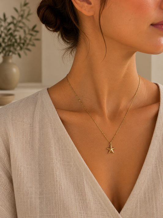 Collar Estrella Marina Dorada BRAVATA, detalle 2: cadena fina con colgante en forma de estrella de mar con textura de pequeños puntos en relieve
