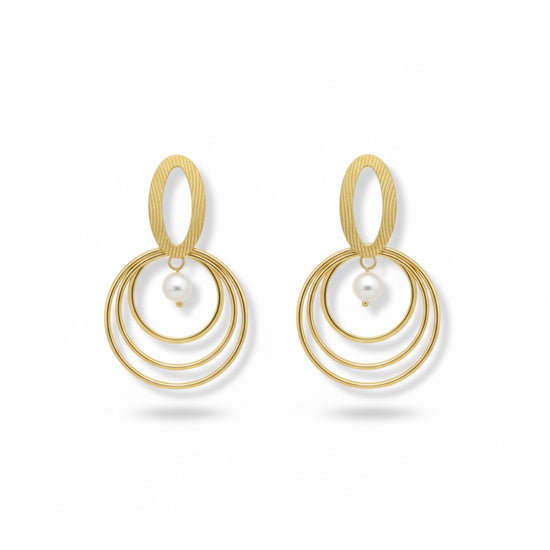 Pendientes dorados con triple aro concéntrico y perla blanca; pieza superior oval texturada (modelo Armonía Perla)