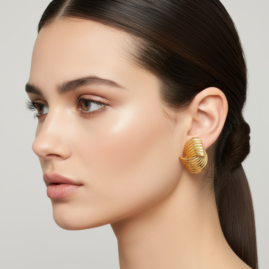 Pendientes Marea Ola dorados en acero inoxidable con textura ondulada sobre modelo