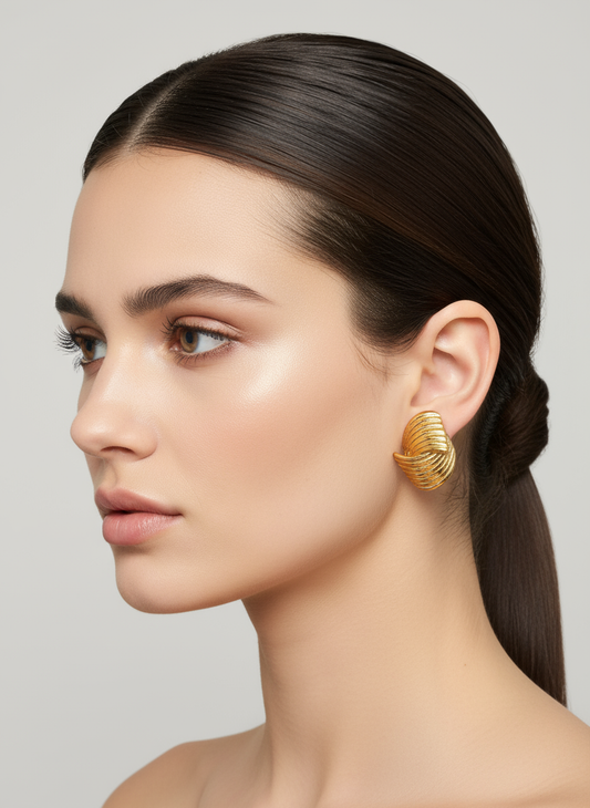 Pendientes Marea Ola dorados en acero inoxidable con textura ondulada sobre modelo