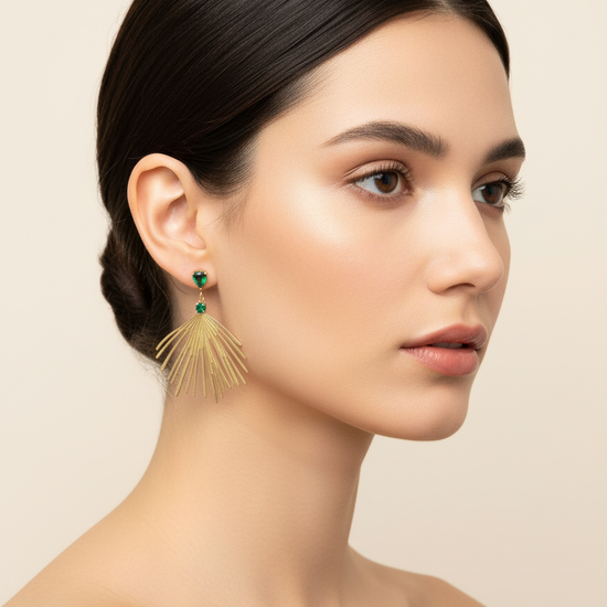 Pendientes largos dorados tipo abanico con cristales verde esmeralda (modelo Palmera Esmeralda) sobre modelo