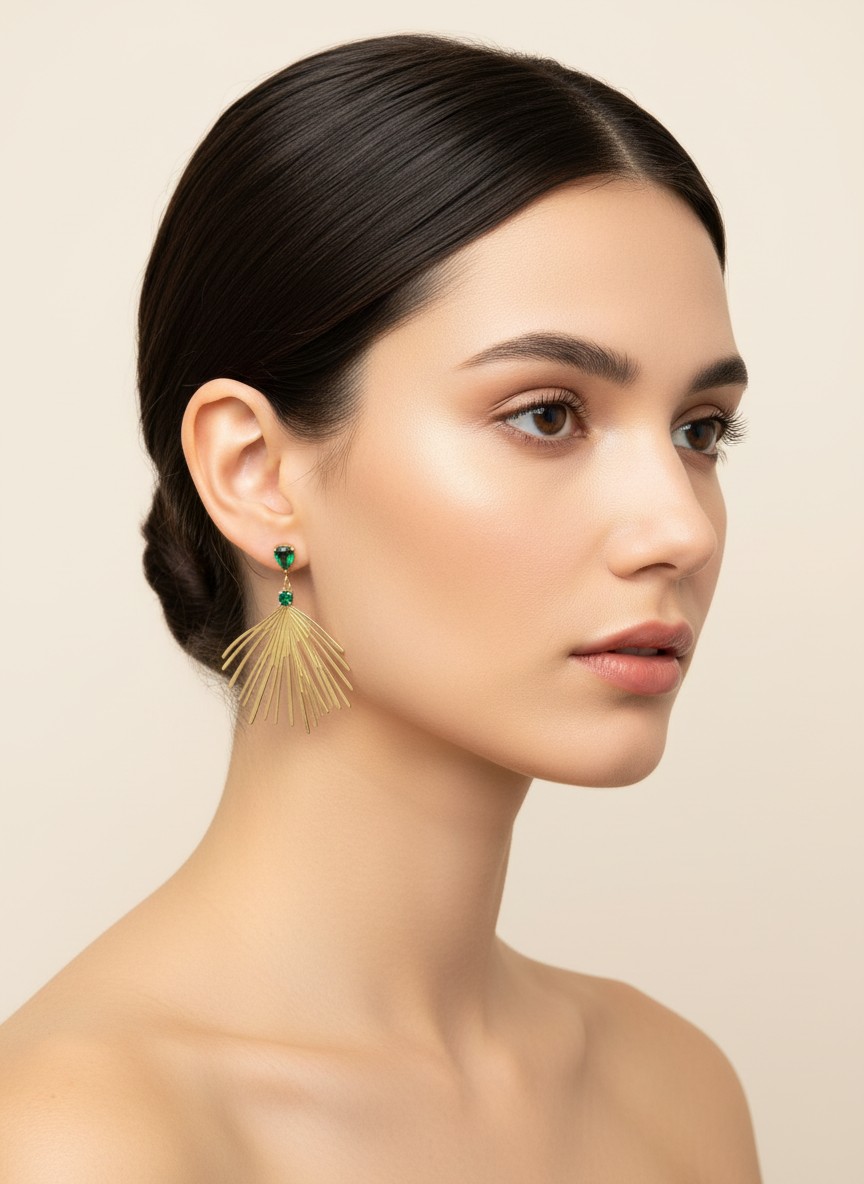 Pendientes largos dorados tipo abanico con cristales verde esmeralda (modelo Palmera Esmeralda) sobre modelo