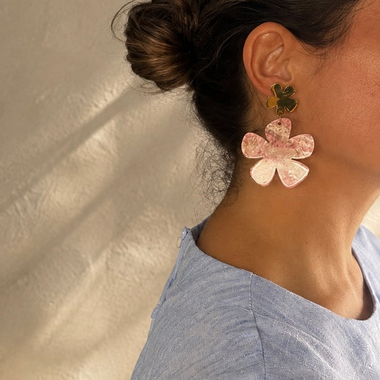 Mujer llevando los Pendientes Solenne BRAVATA de flores rosas y doradas