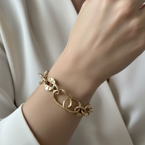 Pulsera de eslabones dorados con discos texturizados en acero con baño de oro 18K sobre modelo