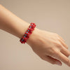 Pulsera crochet hecha a mano en coral o blanco con piedras naturales y acero dorado sobre modelo