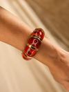 Mujer llevando la Pulsera Carmesia BRAVATA roja y dorada