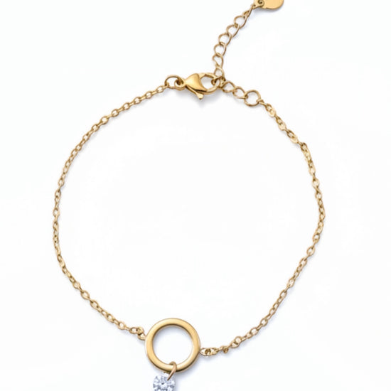 Pulsera dorada con aro central y circonita colgante, en acero con baño de oro 18K