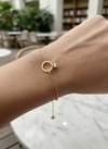 Pulsera dorada con aro central y circonita colgante, en acero con baño de oro 18K