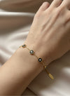 Pulsera dorada con mini discos negros y circonitas, ajustable sobre modelo