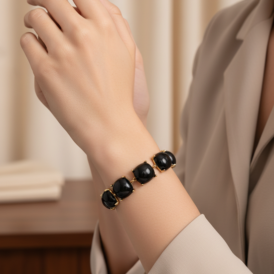 Pulsera dorada con gemas negras cuadradas en talla cushion sobre modelo