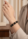 Pulsera dorada con gemas negras cuadradas en talla cushion sobre modelo