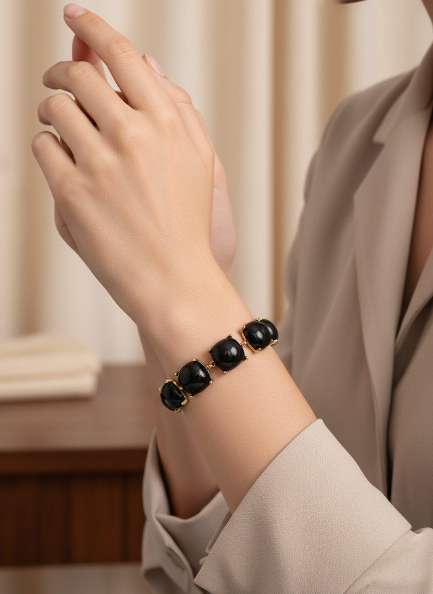 Pulsera dorada con gemas negras cuadradas en talla cushion sobre modelo