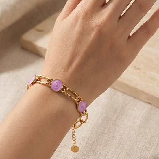 Pulsera dorada de eslabones con tres cabujones rosa en acero con baño de oro 18K sobre modelo