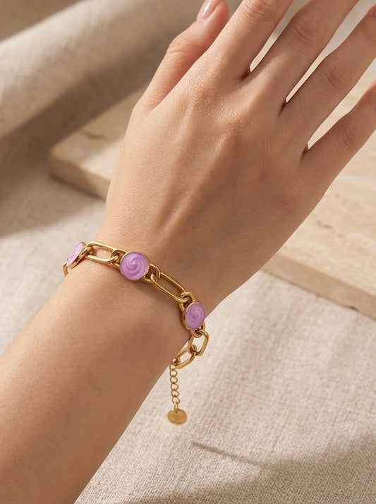 Pulsera dorada de eslabones con tres cabujones rosa en acero con baño de oro 18K sobre modelo