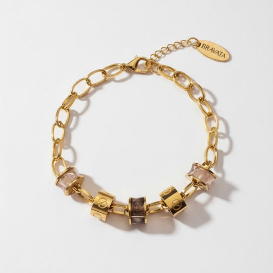 Pulsera dorada con cilindros efecto piedra en tonos nude y ahumado