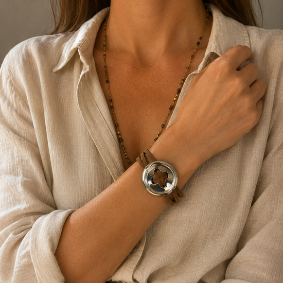 Mujer llevando la Pulsera Sorelia marrón multicordón con pieza circular plateada.