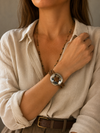 Mujer llevando la Pulsera Sorelia marrón multicordón con pieza circular plateada.