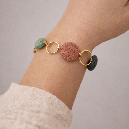 Pulsera con piedras volcánicas en tonos naturales y aros dorados, diseño artesanal y colorido que aporta personalidad y frescura.