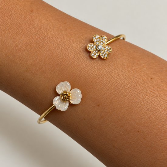 Pulsera Dúo Floral Encantado BRAVATA, detalle 3: pulsera rígida abierta con dos flores en los extremos; una flor con cinco pétalos rojos facetados y centro dora