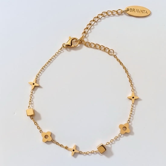 Pulsera dorada con mini charms de estrella, flor y cuadrado en cadena fina