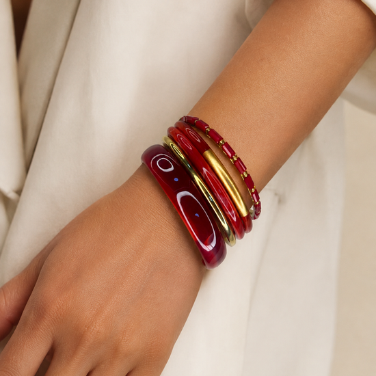 Mujer llevando el Set de Pulseras Calista BRAVATA rojo y dorado