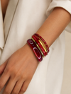 Mujer llevando el Set de Pulseras Calista BRAVATA rojo y dorado