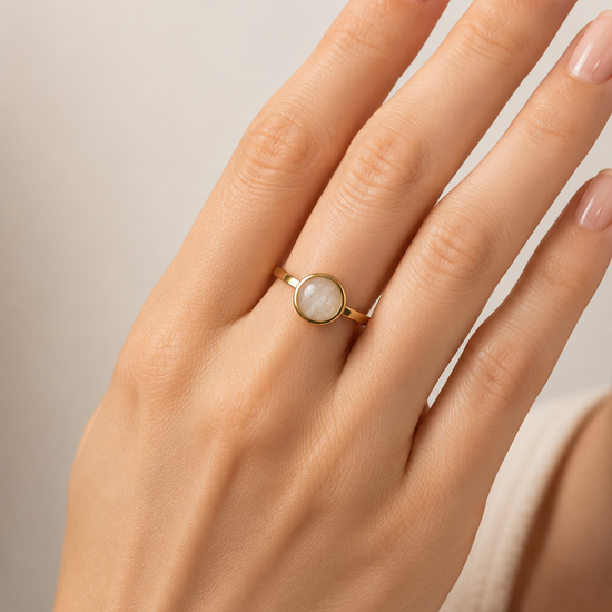 Modelo llevando el Anillo Arven dorado ajustable con piedra circular blanca de BRAVATA.