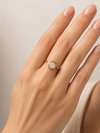 Modelo llevando el Anillo Arven dorado ajustable con piedra circular blanca de BRAVATA.