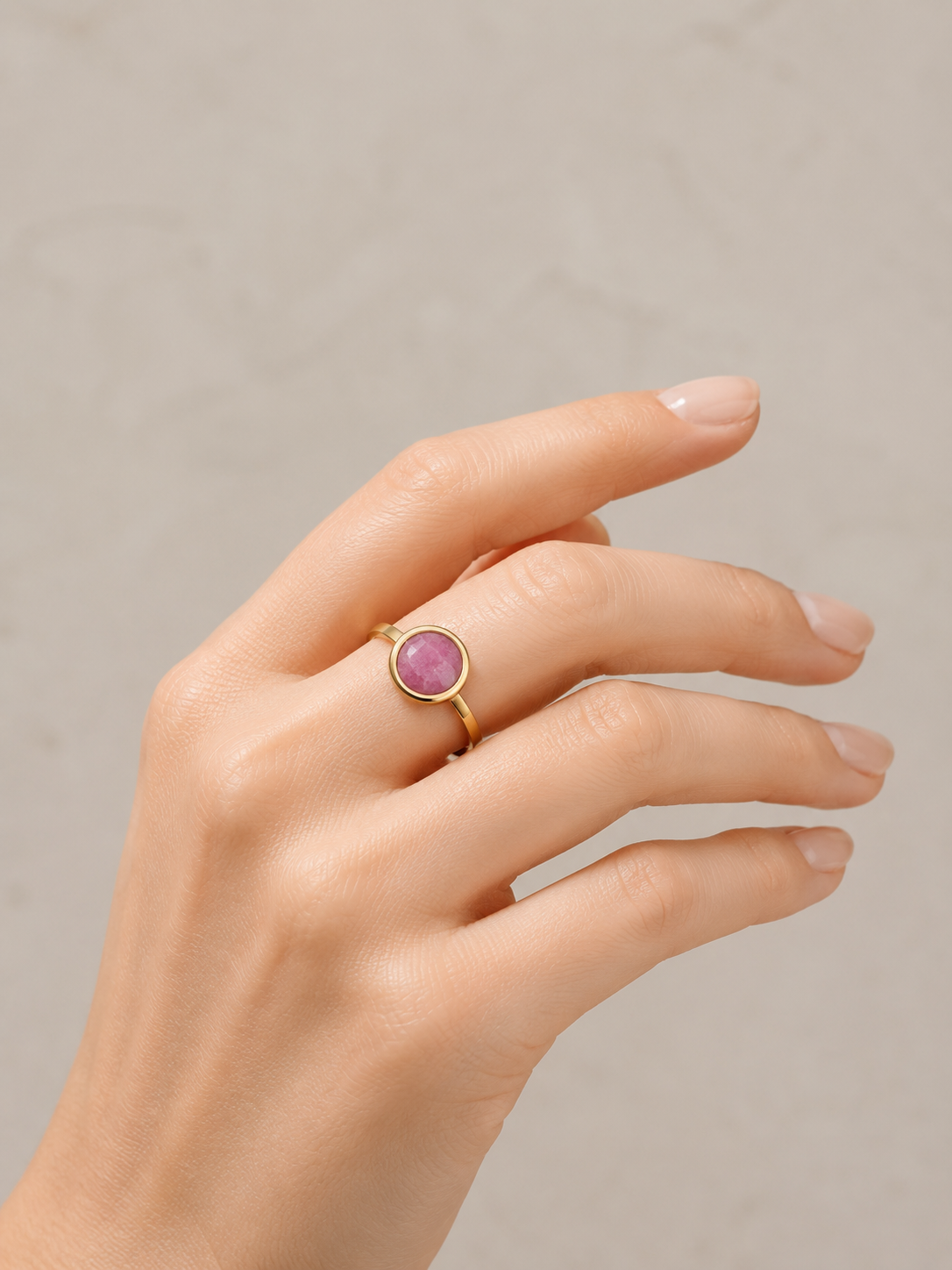 Modelo llevando el Anillo Arven dorado ajustable con piedra circular rosa facetada de BRAVATA.