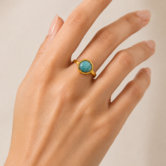 Modelo llevando el Anillo Arven dorado ajustable con piedra circular turquesa de BRAVATA.